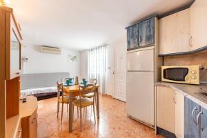 a kitchen with a table with chairs and a microwave at La Noria 3 in El Pozo de los Frailes