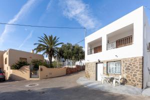 a white house with a table and a palm tree at La Noria 3 in El Pozo de los Frailes