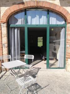 two chairs and a table in front of a window at Studio du Meslay - Fyé in Fyé