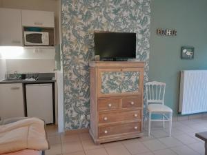 a living room with a tv on top of a dresser at Studio du Meslay - Fyé in Fyé
