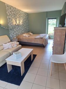 a living room with a bed and a couch at Studio du Meslay - Fyé in Fyé