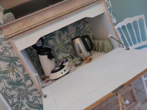 a cupboard with a counter with a coffee maker at Studio du Meslay - Fyé in Fyé