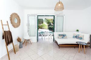 a living room with a white couch and a table at Villa Goyo in Cala en Bosc