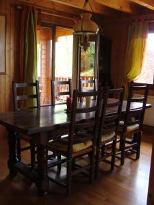 a wooden dining room table with chairs and a dining room at Chalet Jura in Doucier +20 photos
