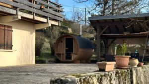 a building with a wooden shelter and some pots at Chalet Jura in Doucier