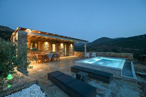a patio with a hot tub and a house at Celini Villas Tinos in Tinos