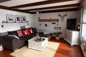 a living room with a couch and a tv at Ferienwohnung Alpenherz 80qm in Blaichach
