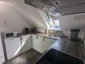 a small kitchen with a sink and a microwave at Ferienwohnung Alafia in Veitsbronn