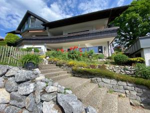 a house with a stone retaining wall and a stone staircase at Ferienwohnung Alpenherz 80qm in Blaichach