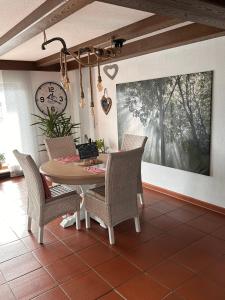a dining room with a table and chairs and a clock at Ferienwohnung Alpenherz 80qm in Blaichach