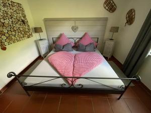 a bedroom with a large bed with pink pillows at Ferienwohnung Alpenherz 80qm in Blaichach