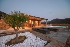 a patio with a tree and a swimming pool at Celini Villas Tinos in Tinos