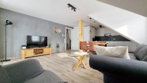 a living room with a couch and a tv at Adlerhorst in Baiersbronn