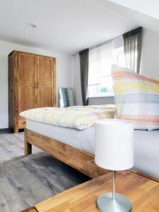 a bedroom with a bed and a table with a lamp at Adlerhorst in Baiersbronn