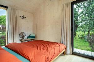 ein Schlafzimmer mit einem Bett und einem großen Fenster in der Unterkunft Tiny House Lachen in Wangen im Allgäu