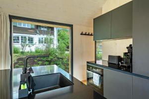 eine Küche mit Spüle und großem Fenster in der Unterkunft Tiny House Lachen in Wangen im Allgäu