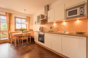 a kitchen with a table and a dining room at Tischlerhof - Typ B mit Balkon in Tirolo +12 photos