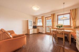 a living room with a table and a couch at Tischlerhof - Typ B mit Balkon in Tirolo