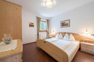a bedroom with a large bed with white sheets at Tischlerhof - Typ B mit Balkon in Tirolo