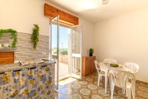 a kitchen and dining room with a table and chairs at La casa di Ulisse 2 in Ispica