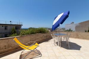 a table and chairs and an umbrella on a patio at La casa di Ulisse 2 in Ispica
