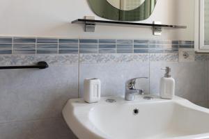 a bathroom with a white sink and a mirror at La casa di Ulisse 2 in Ispica