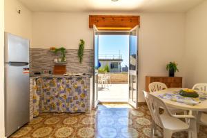 a kitchen with a table and a refrigerator at La casa di Ulisse 2 in Ispica +14 photos