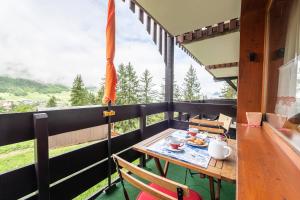 a table with a plate of food on a balcony at Le cheval blanc E7 in Valmorel