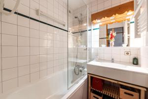 a bathroom with a tub and a sink and a shower at Le cheval blanc E7 in Valmorel