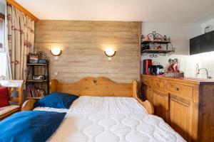 a bedroom with a bed with a wooden head board at Le cheval blanc E7 in Valmorel