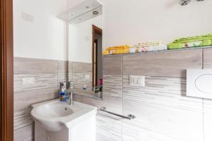 a white bathroom with a sink and a mirror at Appartamento tra mare e montagna in Gaggi +14 photos