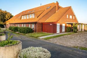 a brick house with an orange roof at Günthers Wattstube in Schweiburg
