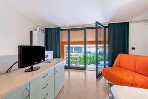 a living room with a tv and a couch in a room at Cozy studio Le Vele Garda Lake in Toscolano Maderno