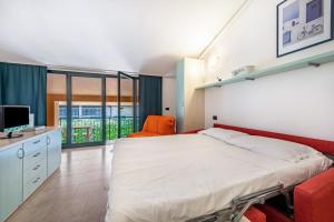a bedroom with a large bed and a television at Cozy studio Le Vele Garda Lake in Toscolano Maderno
