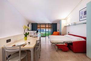 a room with a bed and a table and chairs at Cozy studio Le Vele Garda Lake in Toscolano Maderno