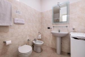 a bathroom with a toilet and a sink and a mirror at Cozy studio Le Vele Garda Lake in Toscolano Maderno +7 photos