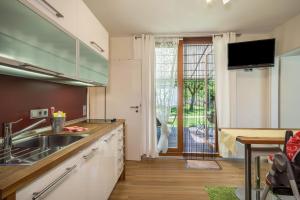 a kitchen with a sink and a sliding glass door at Ferienhaus Im Tobel in Deggenhausertal