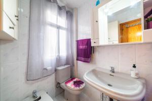 a bathroom with a toilet and a sink and a mirror at Mccoy avenida 3 in Macael +17 photos
