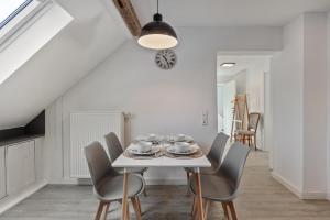 a white dining room with a white table and chairs at Ferienwohnung am Blitzgi in Wehr