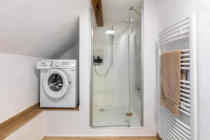 a bathroom with a washing machine and a shower at Ferienwohnung am Blitzgi in Wehr +17 photos