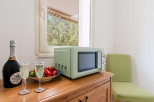 a television and two glasses of champagne on a dresser at Andromeda's Rooms in Otranto +68 photos