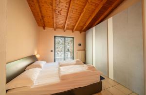 a bedroom with a large bed with a wooden ceiling at Central Penthouse Luino in Luino