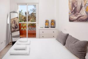 a white room with a bed and a mirror at Apartamento Baviera Golf 002 in Vélez-Málaga +22 photos
