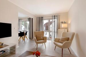 a living room with two chairs and a flat screen tv at Sabines Ferienwohnung 2 in Glückstadt