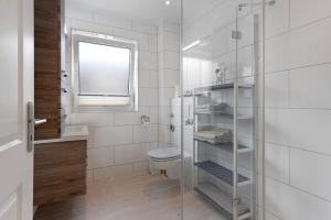 a bathroom with a toilet and a glass shower at Sabines Ferienwohnung 2 in Glückstadt +13 photos