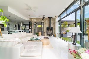 a living room with white furniture and large windows at Prestigieuse Villa Spa 2 Piscines in Saint-Gély-du-Fesc