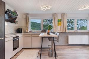 a kitchen with a table and some windows and a counter at Ferienwohnung im Grünen in Oberried