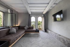 a living room with a couch and a tv at Suite Deluxe Torre in San Gimignano
