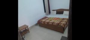 a small bedroom with a bed and a chair at Hotel prayag with ev car station 7,4kw in Nāthdwāra