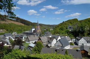 a town with houses and a church in the distance at Rothaarsteig Ferienhaus in Kirchhundem